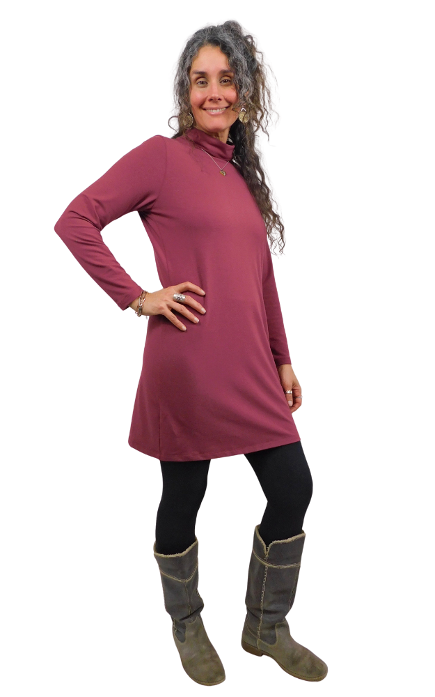Woman wearing a wine coloured dress with long sleeves and cowl neck on a white background