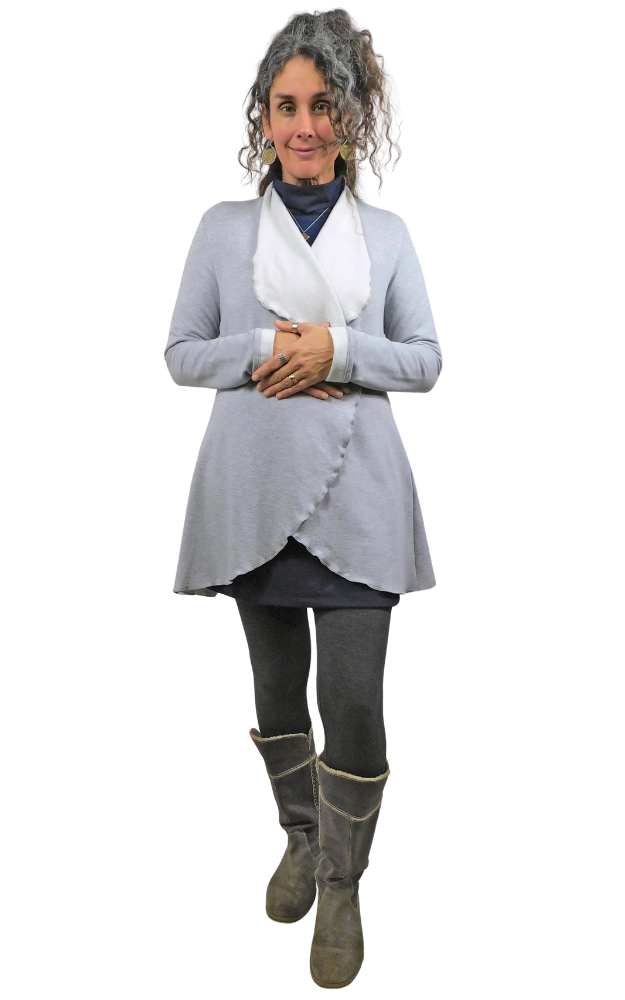 Woman wearing a light gray cardigan, dark tights, and gray boots on a white background