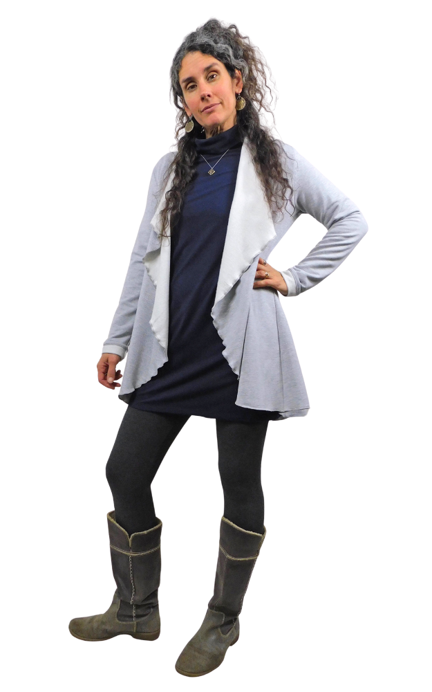 Woman wearing a gray cardigan, dark dress, black leggings, and gray boots on a white background
