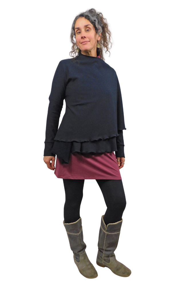 Woman wearing a layered outfit with a black top and pink skirt on a white background