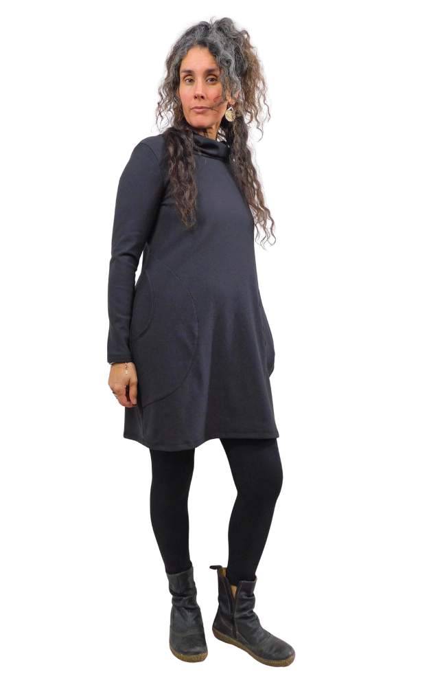 Woman wearing a long sleeve black tunic dress against a white background