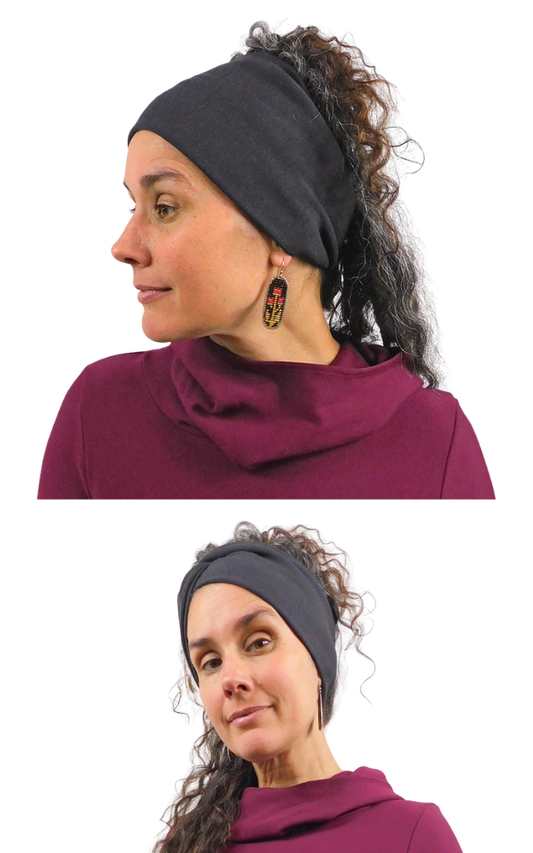 A woman modeling a dark charcoal gray fabric headband in two side-profile views against a white background. She is wearing a deep plum-purple top and colorful dangling earrings.