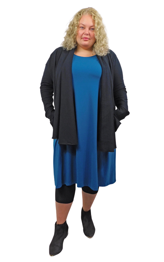 Woman wearing a blue dress and black cardigan on a white background