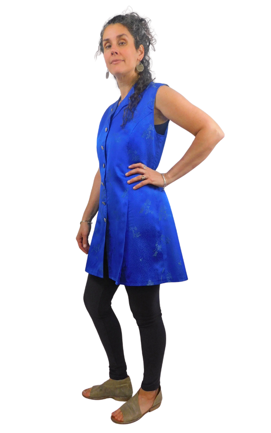 Woman wearing a blue sleeveless dress with a white background