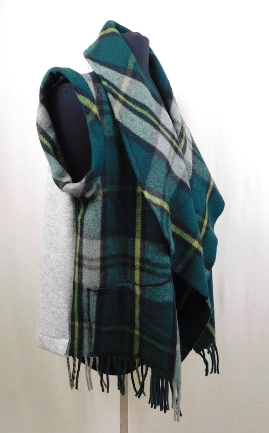 A green and blue tartan patterned Merino wool vest with fringe detail on the back, displayed on a mannequin.