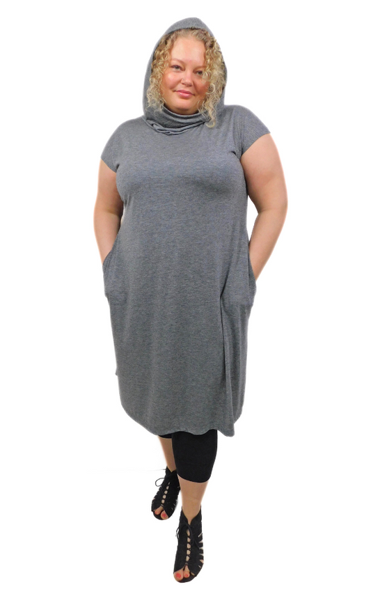 Large size woman standing with hands in pocket wearing lightweight charcoal tunic long dress with loose hood worn up
