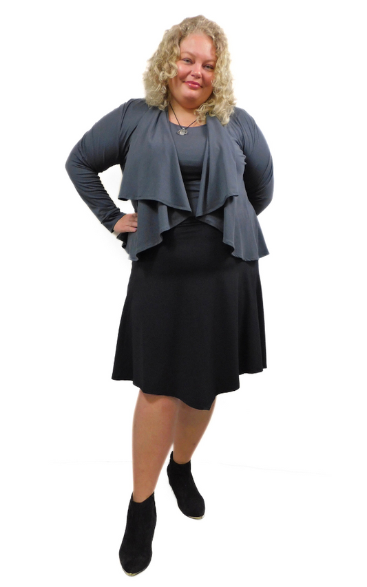 Woman wearing a gray cardigan, a gray top and black skirt on a white background