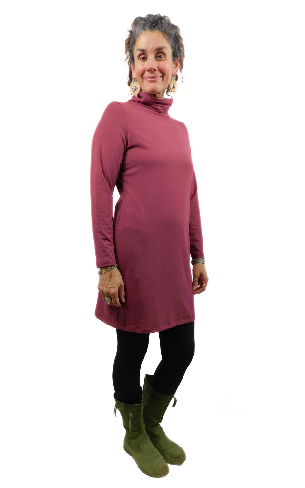 Woman wearing a long burgundy dress with a turtleneck on a white background