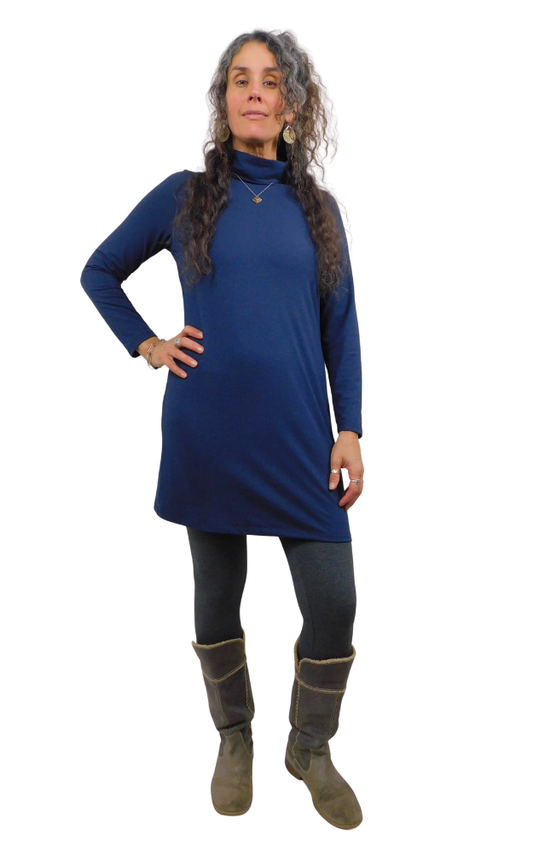 Woman wearing a blue dress and gray boots on a white background
