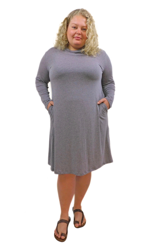 Plus size woman wearing long sleeve dress with hands in pockets