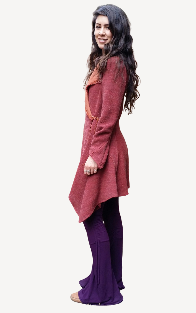 Woman wearing a long maroon coat and purple pants on a white background