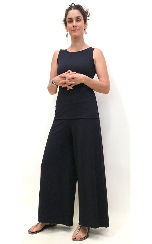 woman wearing black tank top and long wide black pants