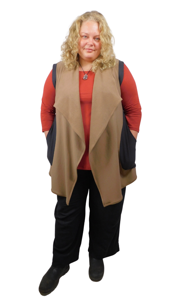 Woman wearing a beige vest over a red shirt with black pants on a white background