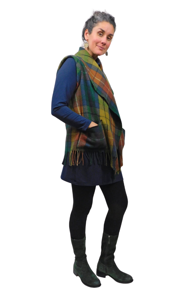 Woman wearing a tartan vest over a dark outfit on a white background