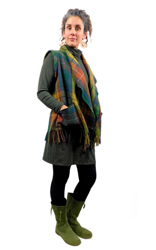 Woman wearing a tartan vest over a dark outfit on a white background