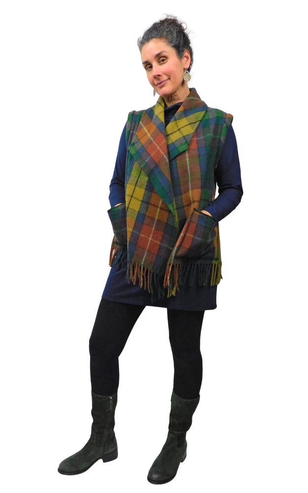 Woman wearing a tartan vest over a dark outfit on a white background