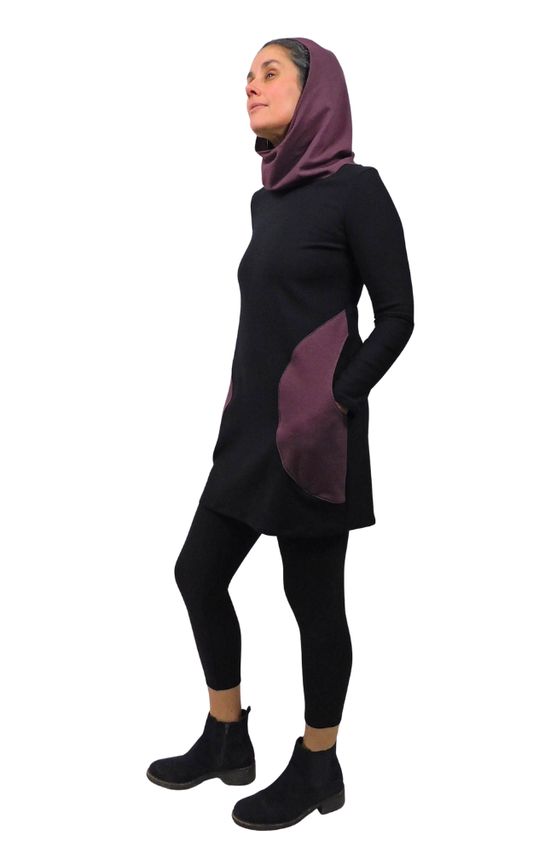 Woman wearing a black and purple outfit with a hood on a white background