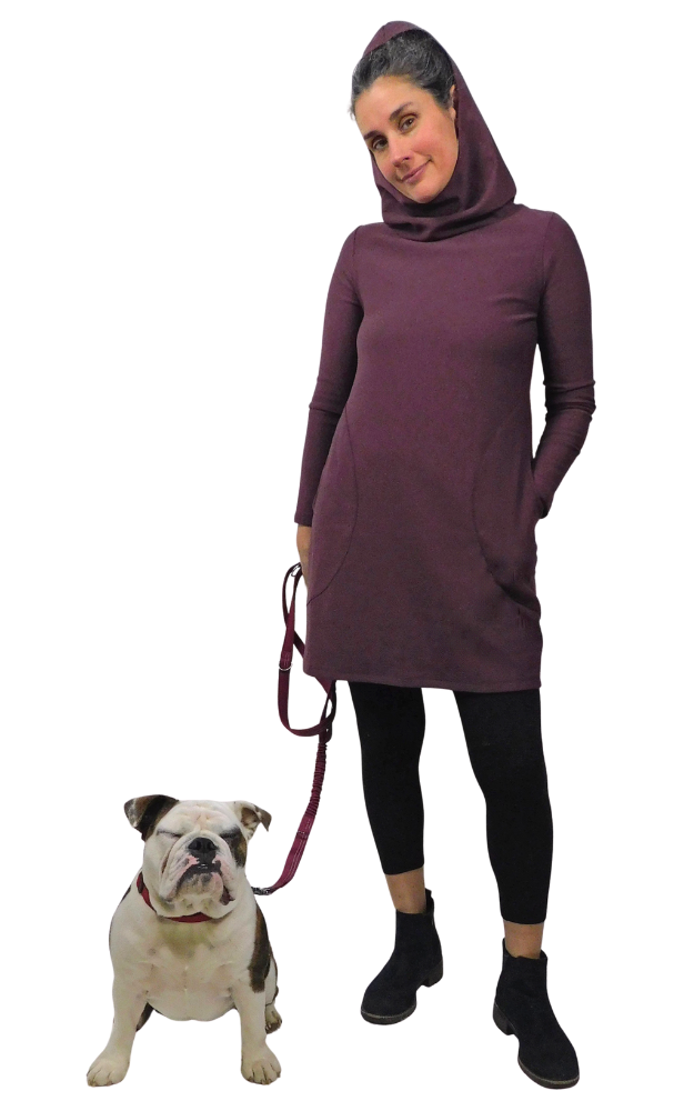 Woman wearing long sleeve hooded burgandy tunic & black tights with bulldog on leash