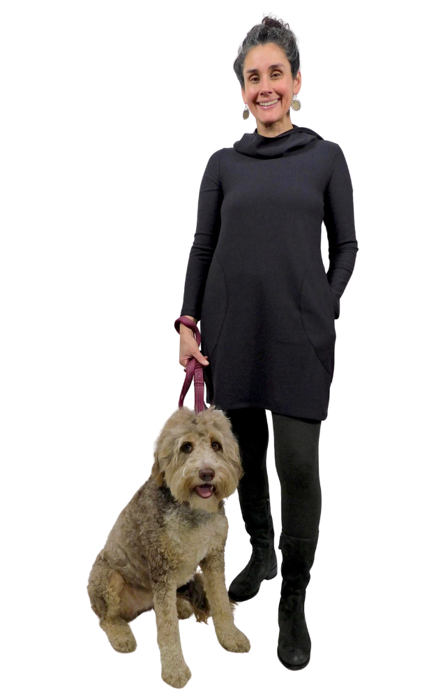 Woman in a black dress standing next to a dog on a white background
