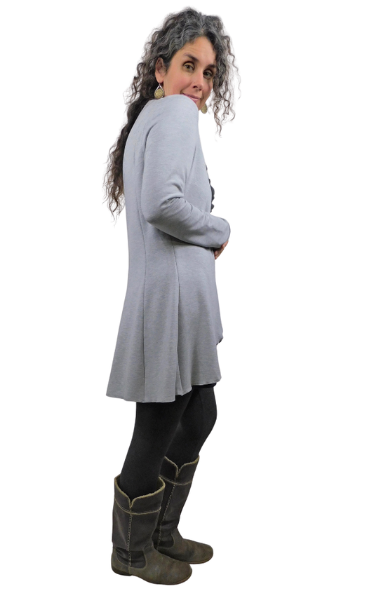 Person wearing a light gray long-sleeve cardigan and dark pants on a white background