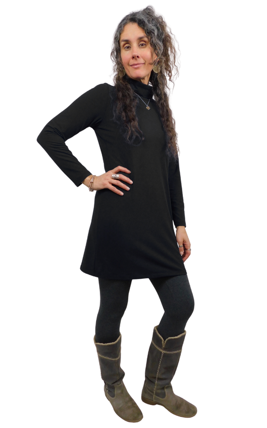 Woman wearing a black dress and brown boots on a white background