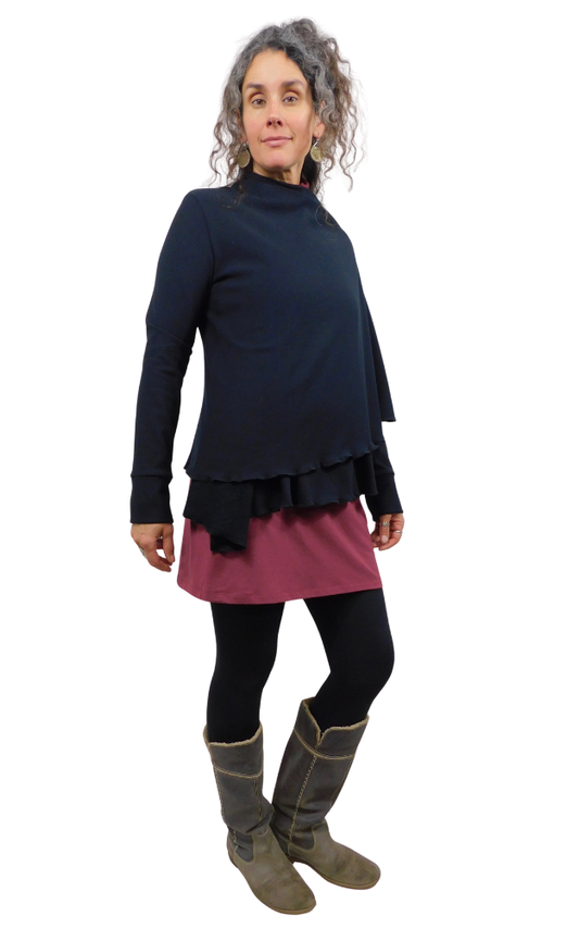 Woman wearing a black top and wine coloured skirt with gray boots on a white background