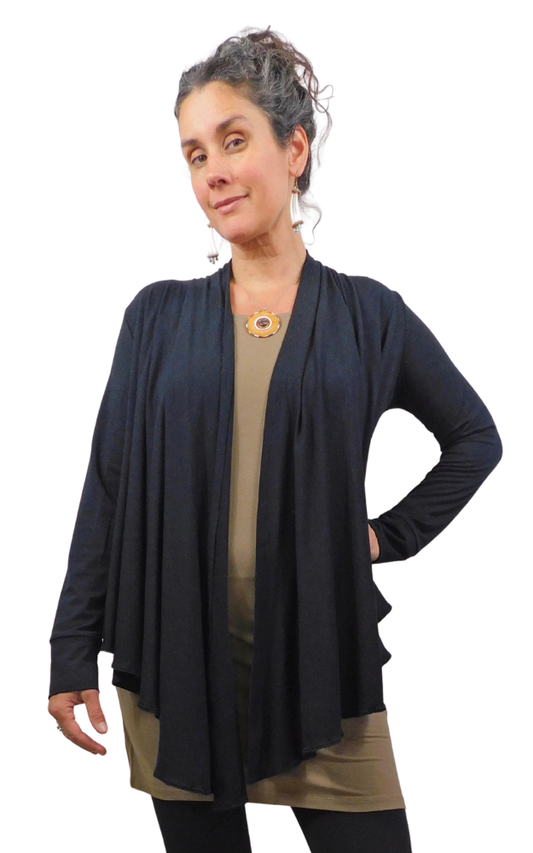 Woman wearing a black sweater over a beige dress