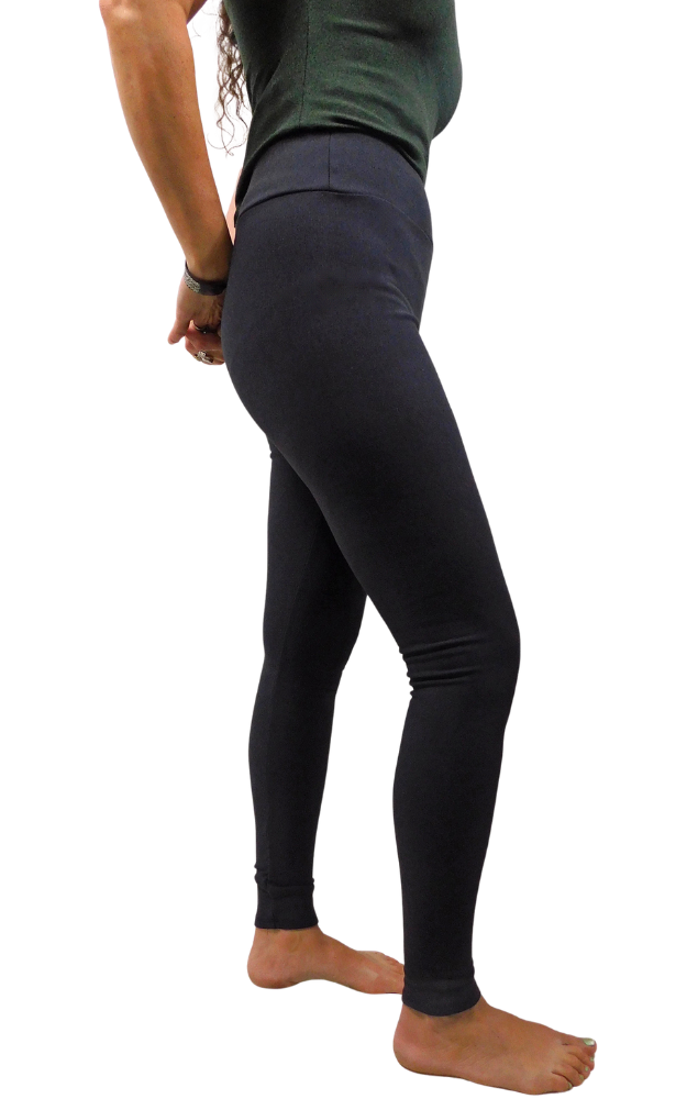 A side profile view of a person wearing black leggings, standing barefoot against a solid white background.