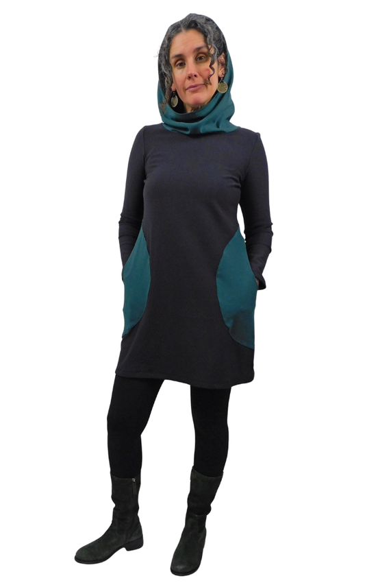 Woman wearing black tunic with green hood and pockets on a white background.