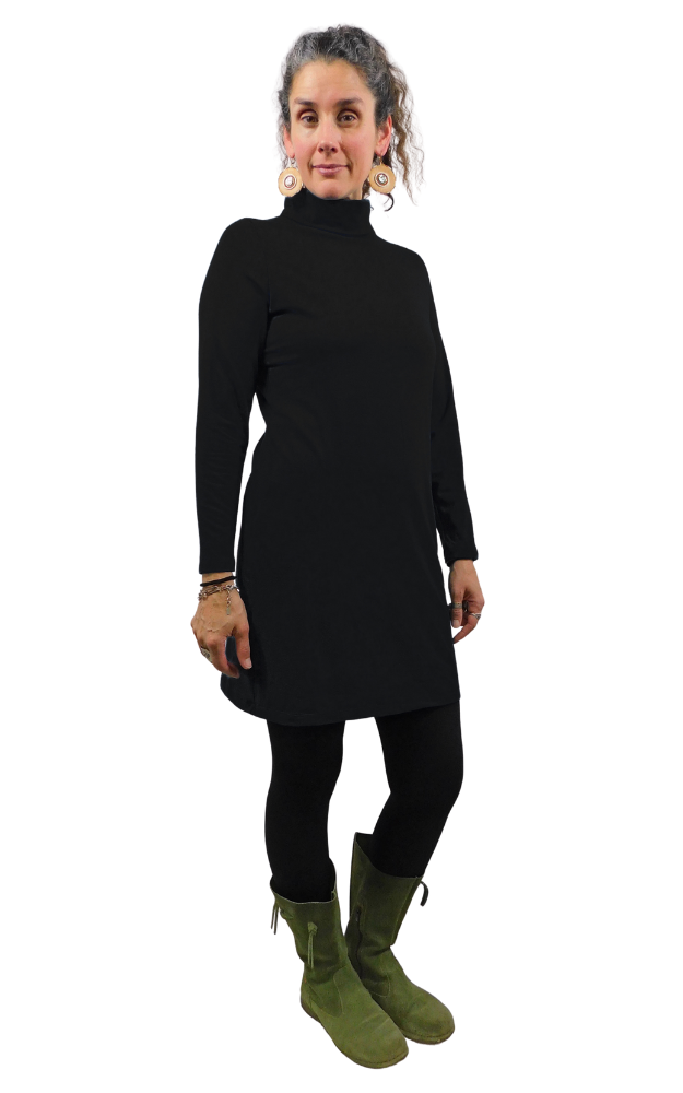 Woman wearing a black turtleneck dress and green boots on a white background
