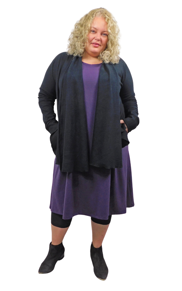 Woman wearing a black cardigan over a purple dress on a white background