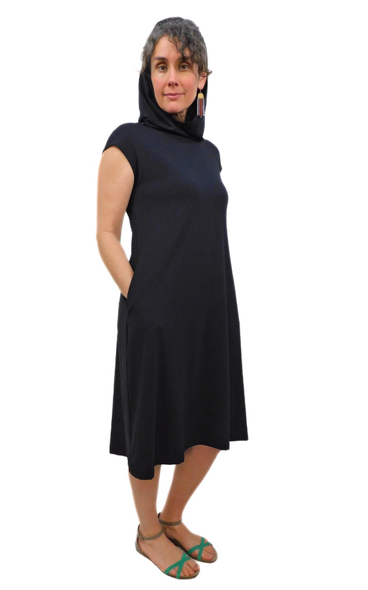 Model Size Medium wearing hood up Black capped sleeve wide long tunic dress with side pockets and large hood that can drape around the neck as a cowl. Garment is made from a 
High Twist Jersey knit w/Spandex, with a lovely stretch and drape. 