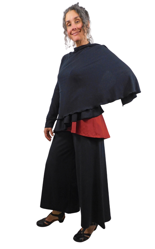 Woman wearing a black outfit of red top and black wrap sweater and black pants on a white background