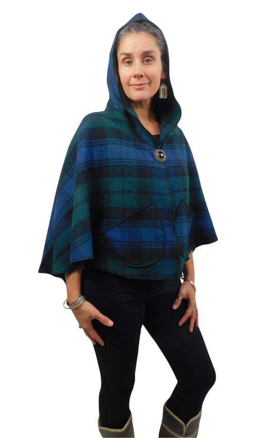 Woman wearing a blue and green and black tartan cape with front brooch, worn  with hood up and front  patch pockets