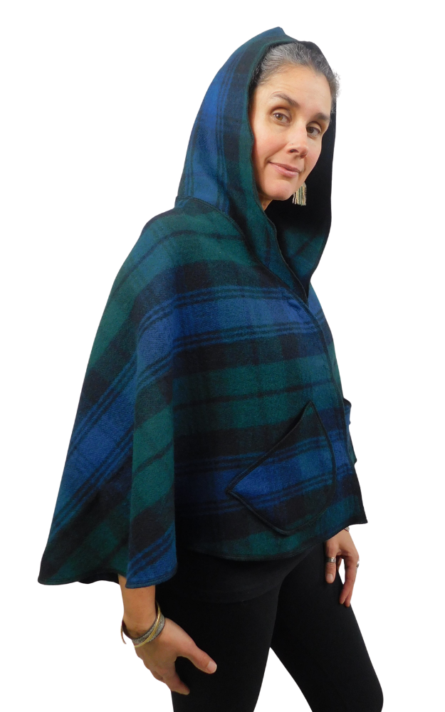 Woman wearing a blue and green and black tartan cape with hood up and front  patch pockets