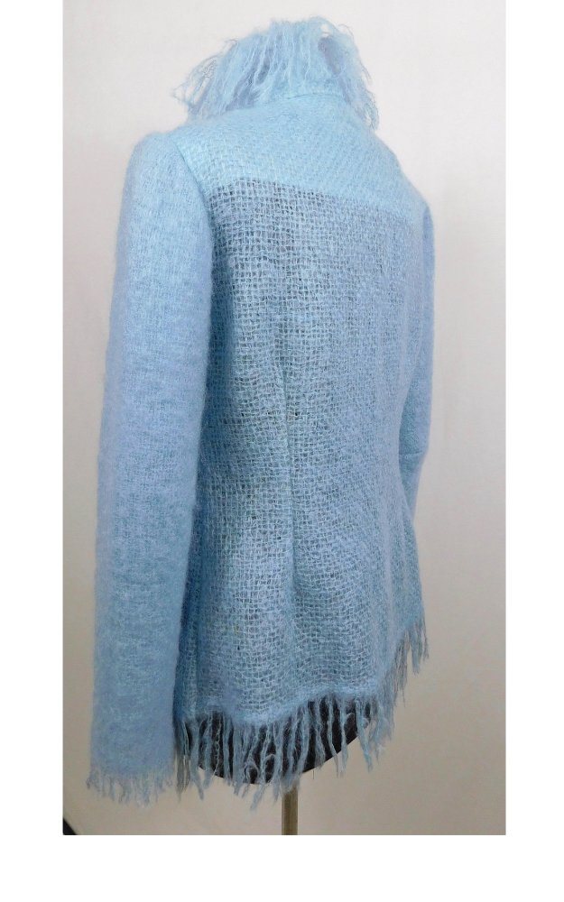 Light blue knitted jacket with fringe on a mannequin against a white background