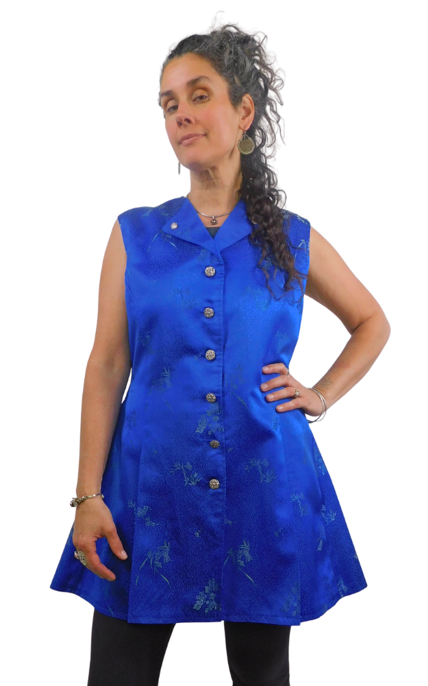 Woman wearing a blue sleeveless dress with buttons on a white background