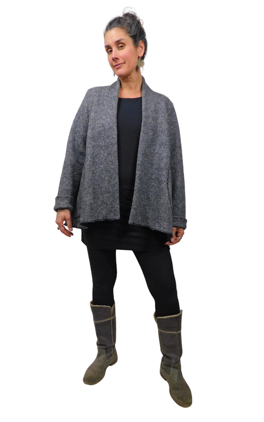 Woman wearing charcoal wool coat open at front and black tights and grey boots