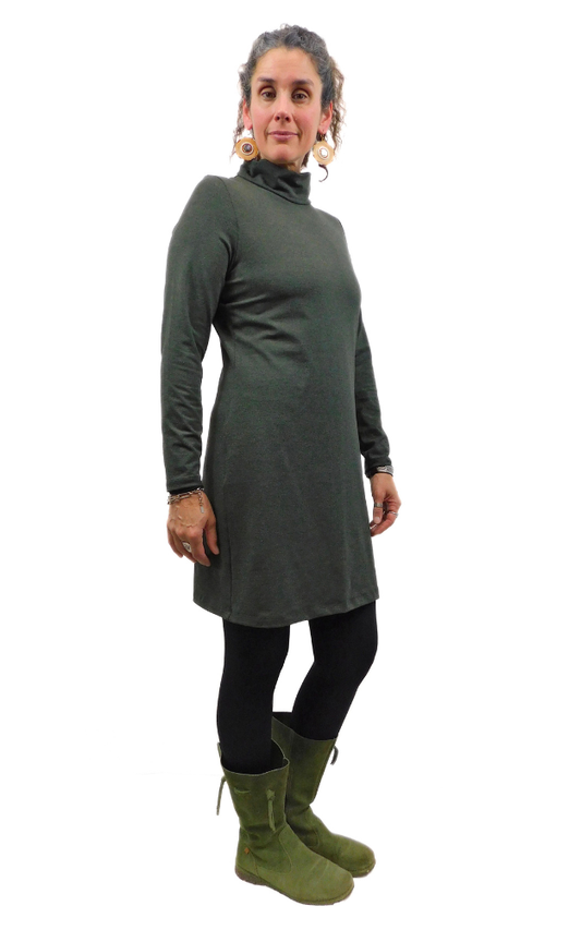 Woman wearing a long-sleeve green dress with a white background