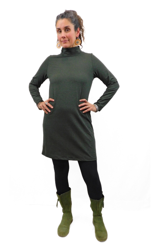 Woman wearing a green turtleneck dress and green boots on a white background