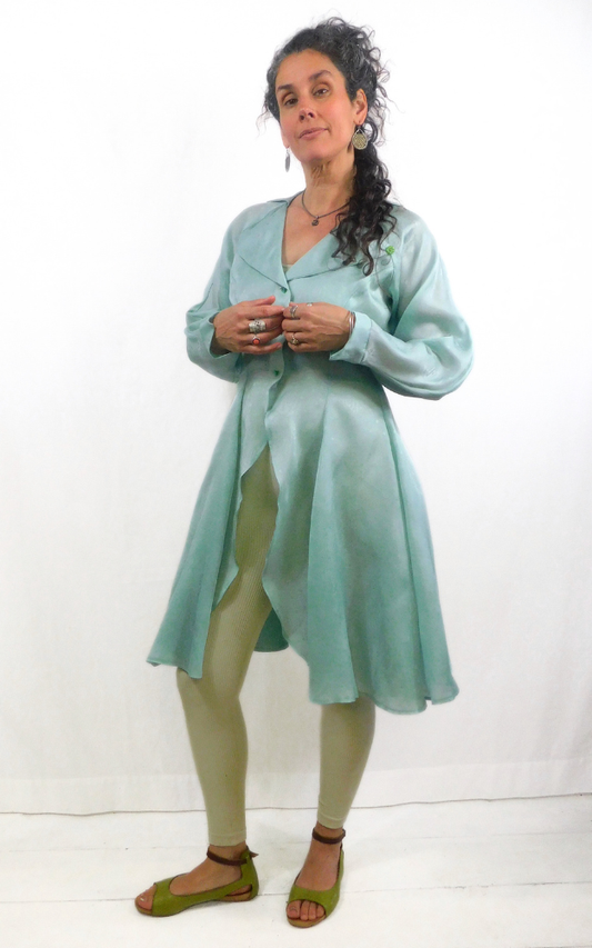 Woman wearing a light green dress with a white background