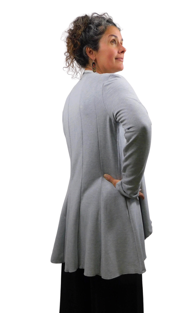 A woman shown from the back wearing a light gray long-sleeve panel style cardigan with black pants, photographed against a plain white background.