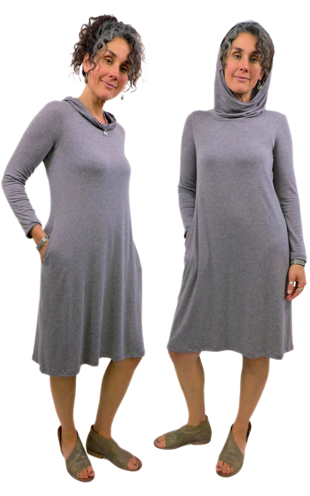 Two figures wearing long sleeve dress, one with hood up, hands in pocket 