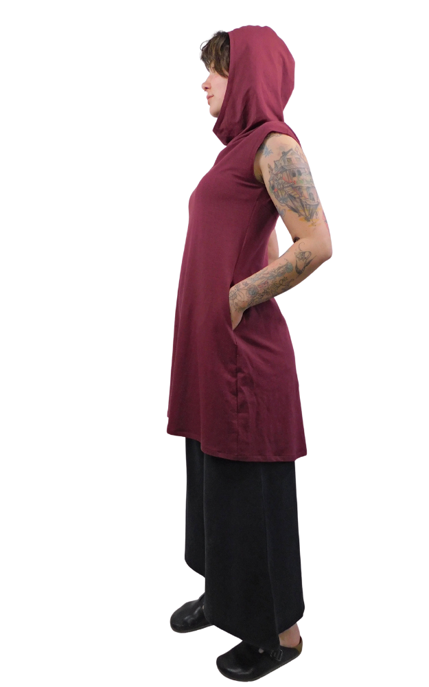 Person wearing a burgundy sleeveless hoodie with a hood on a white background