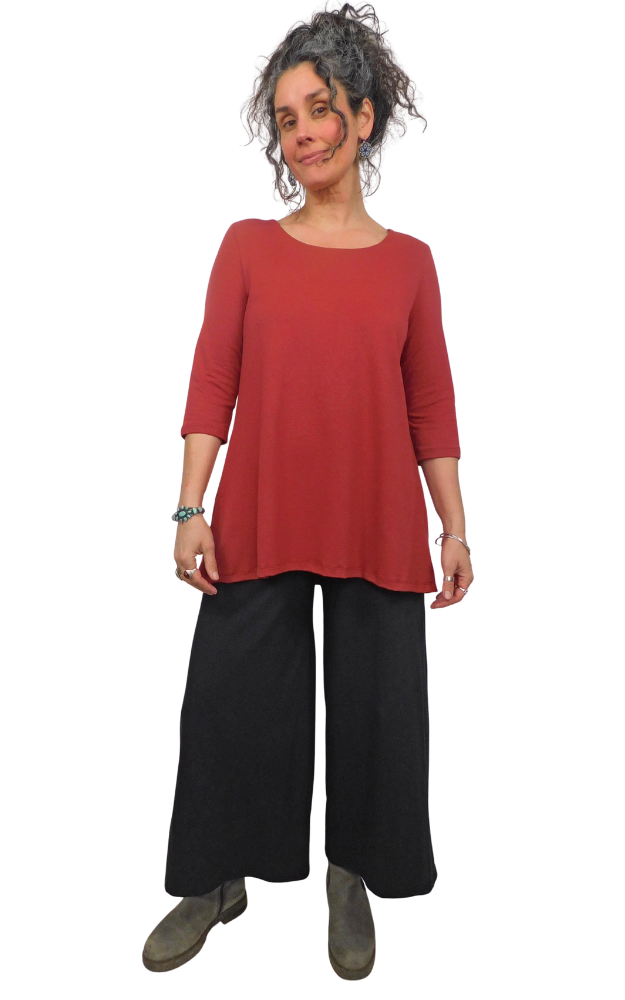 Woman wearing a red top and black pants on a white background