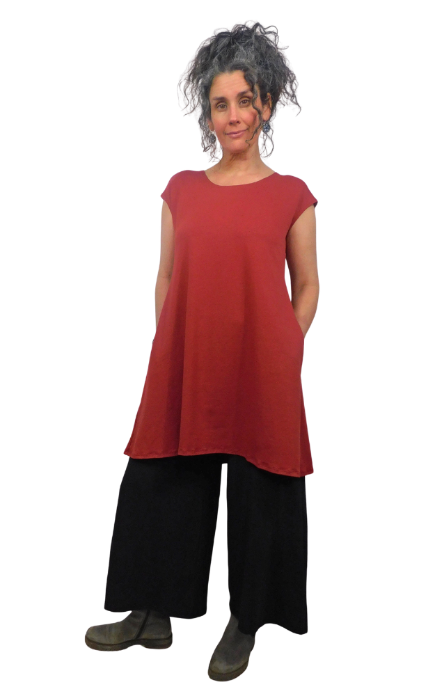 Person wearing a red sleeveless top and black pants on a white background