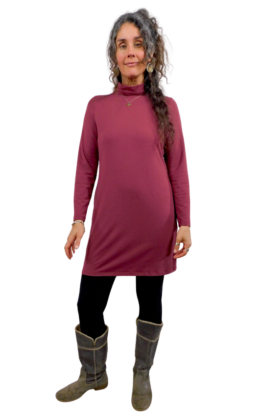 Woman wearing a long-sleeve dress with a turtleneck and boots on a white background