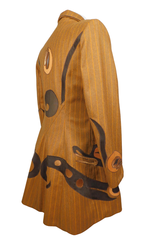 Striped golden brown coat with native art design on skirt and cuff, showing back side view
