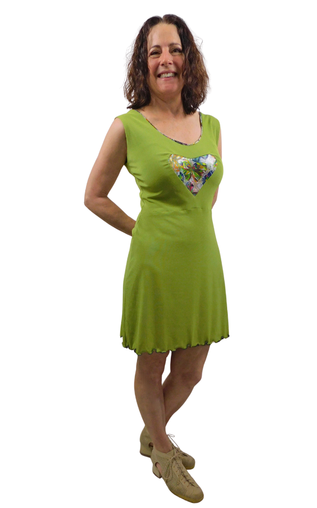 Woman wearing a green dress with a floral design shaped in a heart on a white background