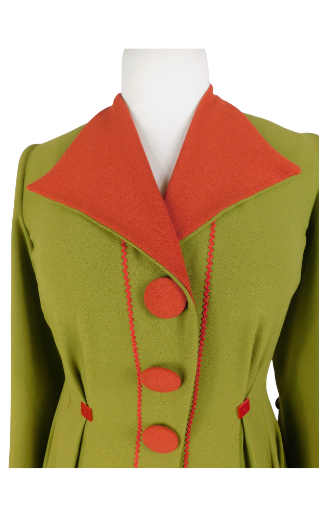 Green coat with red collar and buttons on a mannequin against a white background